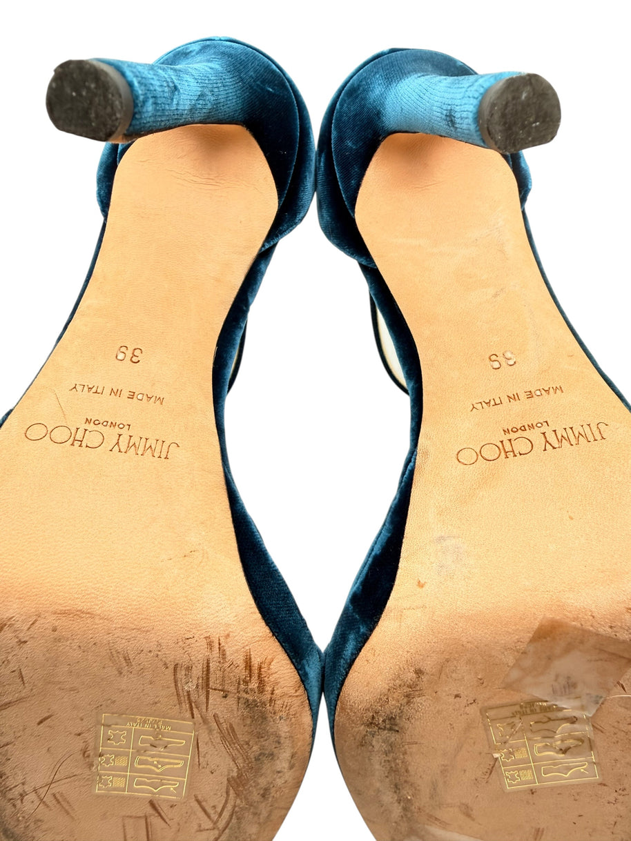 Close-up of Jimmy Choo Misty 120 teal velvet stiletto heel tips and leather soles showing original branding, size 39 and signs of use.