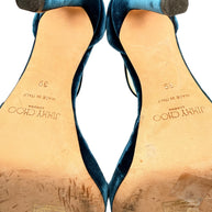 Close-up of Jimmy Choo Misty 120 teal velvet stiletto heel tips and leather soles showing original branding, size 39 and signs of use.