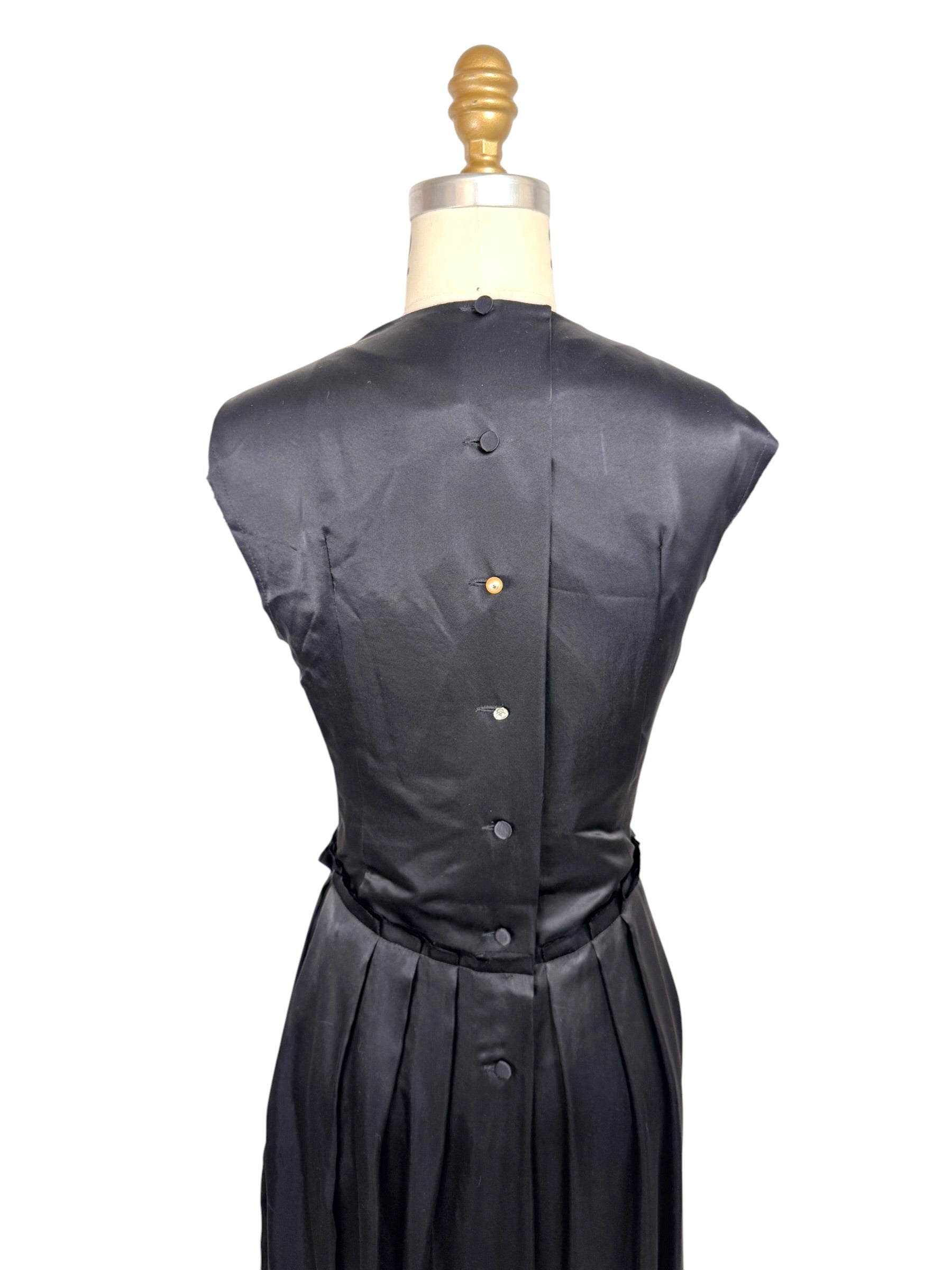 Close back detail of Lanvin Hiver 2005 black satin dress showing covered button closures and smooth satin finish.