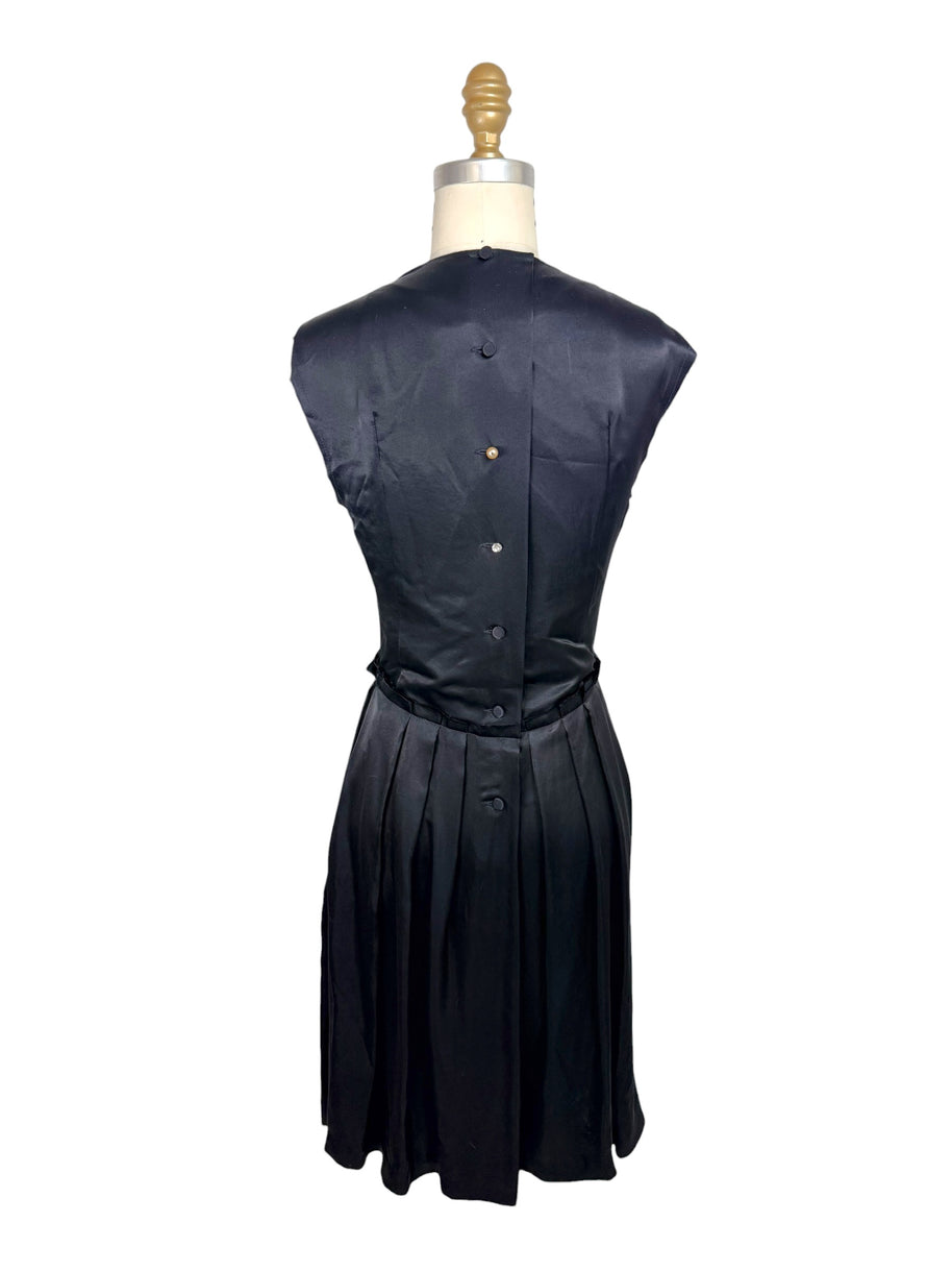Full back view of Lanvin Hiver 2005 black satin dress featuring covered button closures and softly pleated skirt.