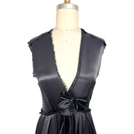 Close front detail of Lanvin Hiver 2005 black satin dress showing deep plunge neckline with frayed trim and sculptural satin rosette accent.