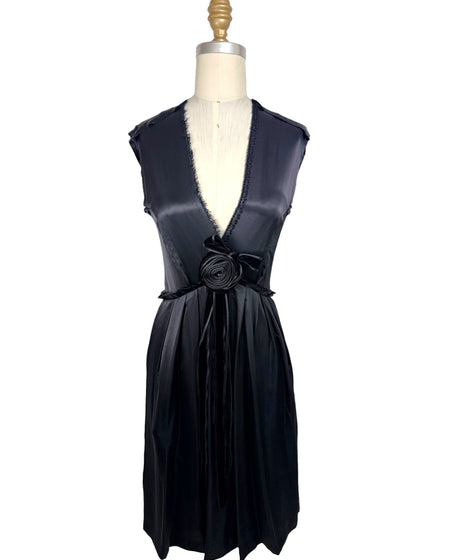 Front full view of Lanvin Hiver 2005 black satin sleeveless dress with plunging neckline, pleated skirt, and tonal rosette waist detail on mannequin.