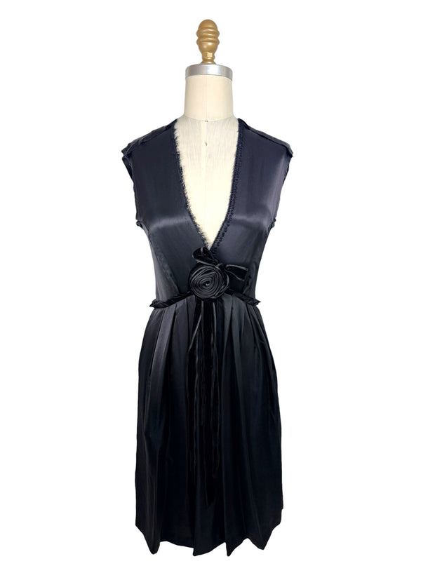 Front full view of Lanvin Hiver 2005 black satin sleeveless dress with plunging neckline, pleated skirt, and tonal rosette waist detail on mannequin.