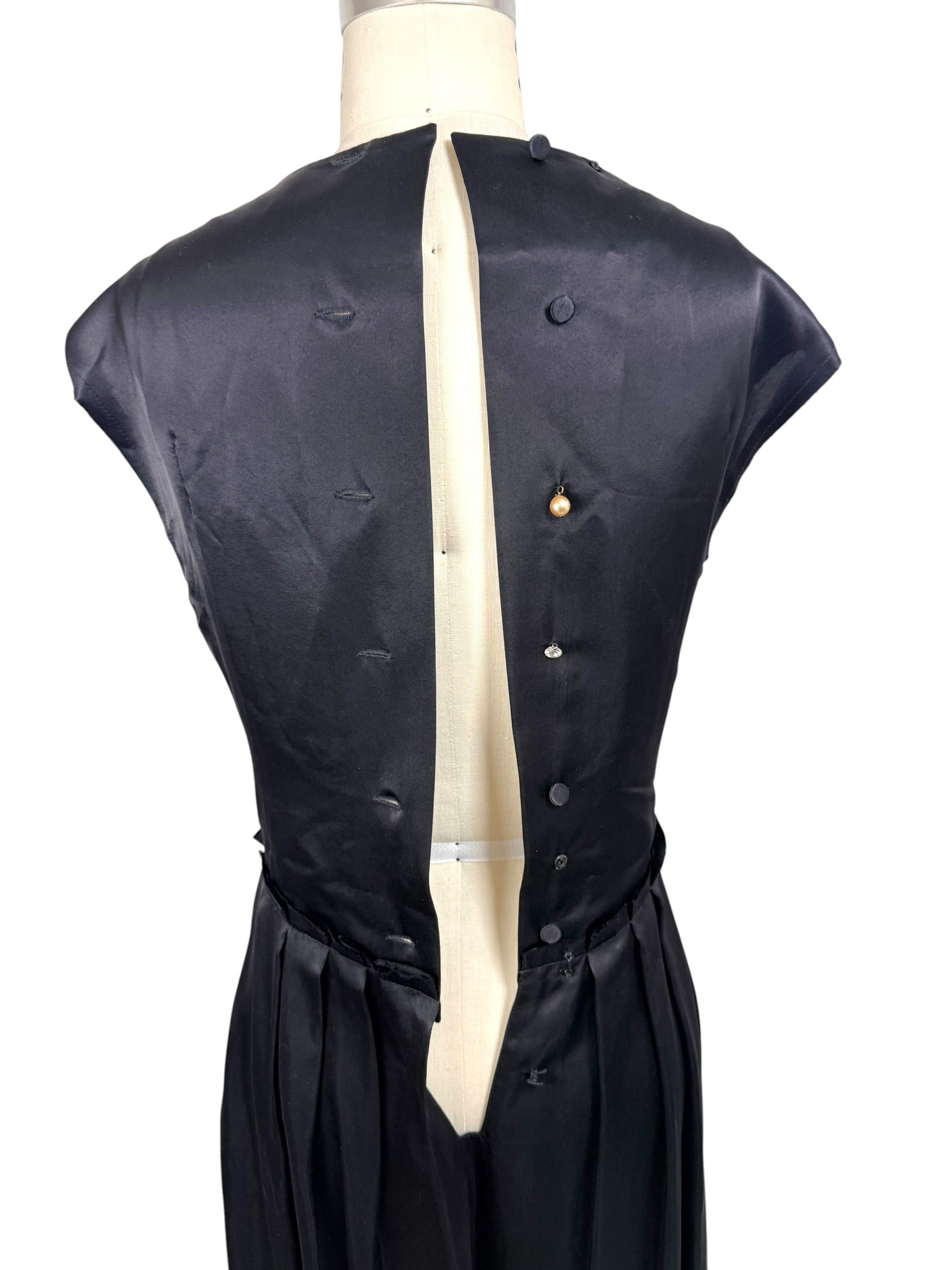 Interior back construction view of Lanvin Hiver 2005 black satin dress displaying covered button closures and interior finishing.