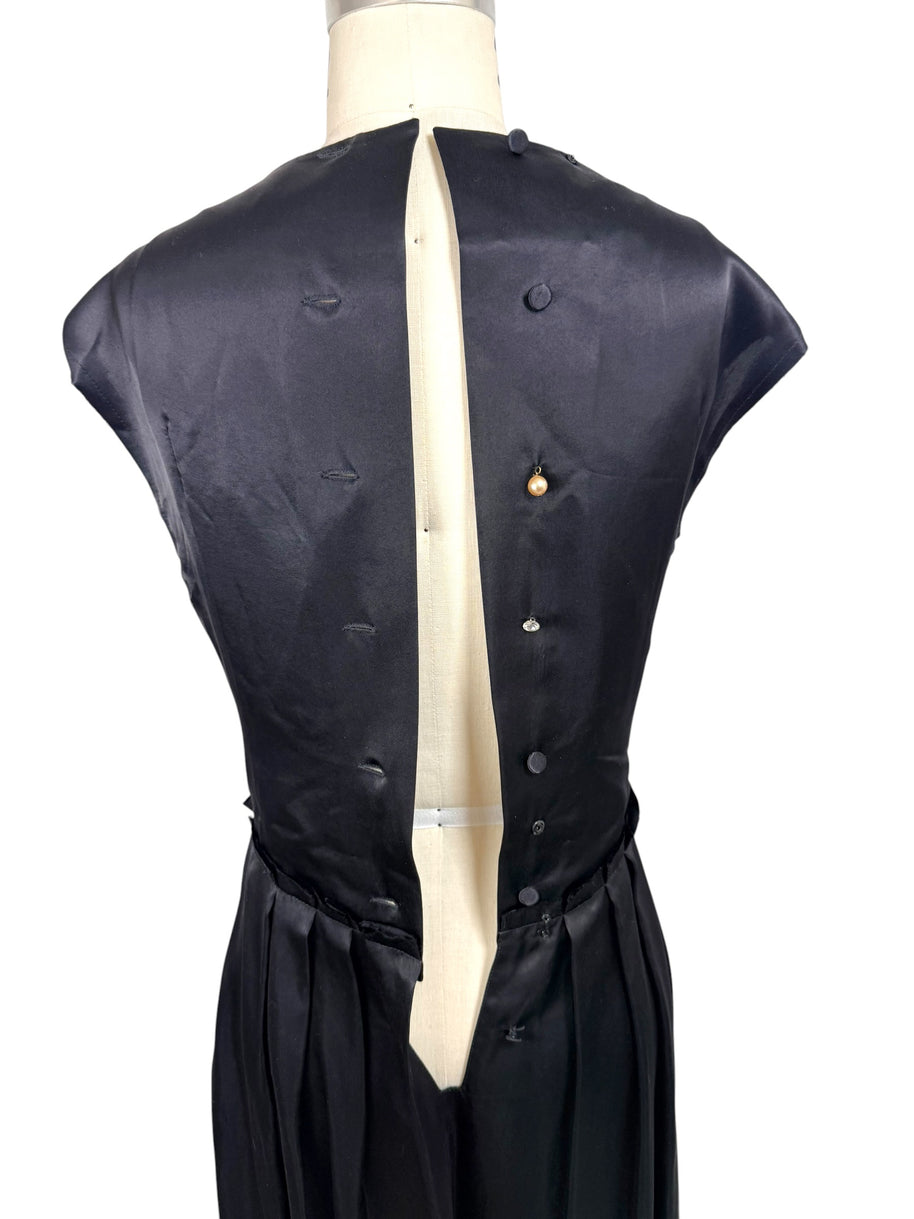 Interior back construction view of Lanvin Hiver 2005 black satin dress displaying covered button closures and interior finishing.