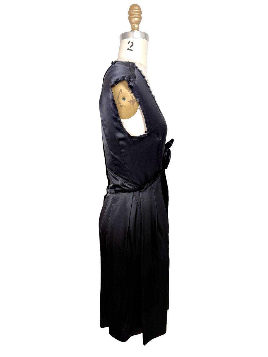 Left side profile view of Lanvin Hiver 2005 black satin pleated dress with fluid silhouette and sleeveless construction.