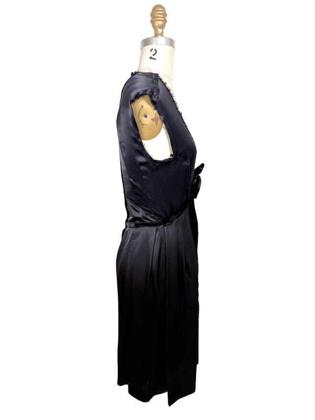 Left side profile view of Lanvin Hiver 2005 black satin pleated dress with fluid silhouette and sleeveless construction.