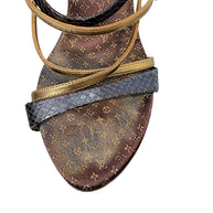 Close-up of Louis Vuitton vintage Monogram sandal showing brown and gold footbed, metallic gold straps and dark textured toe strap