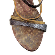 Close-up of Louis Vuitton Monogram sandal toe showing metallic gold leather and dark textured strap detailing