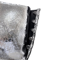 Close-up of Maison Margiela silver Tabi ankle boot showing concealed hook closure and intentional cracked metallic leather finish