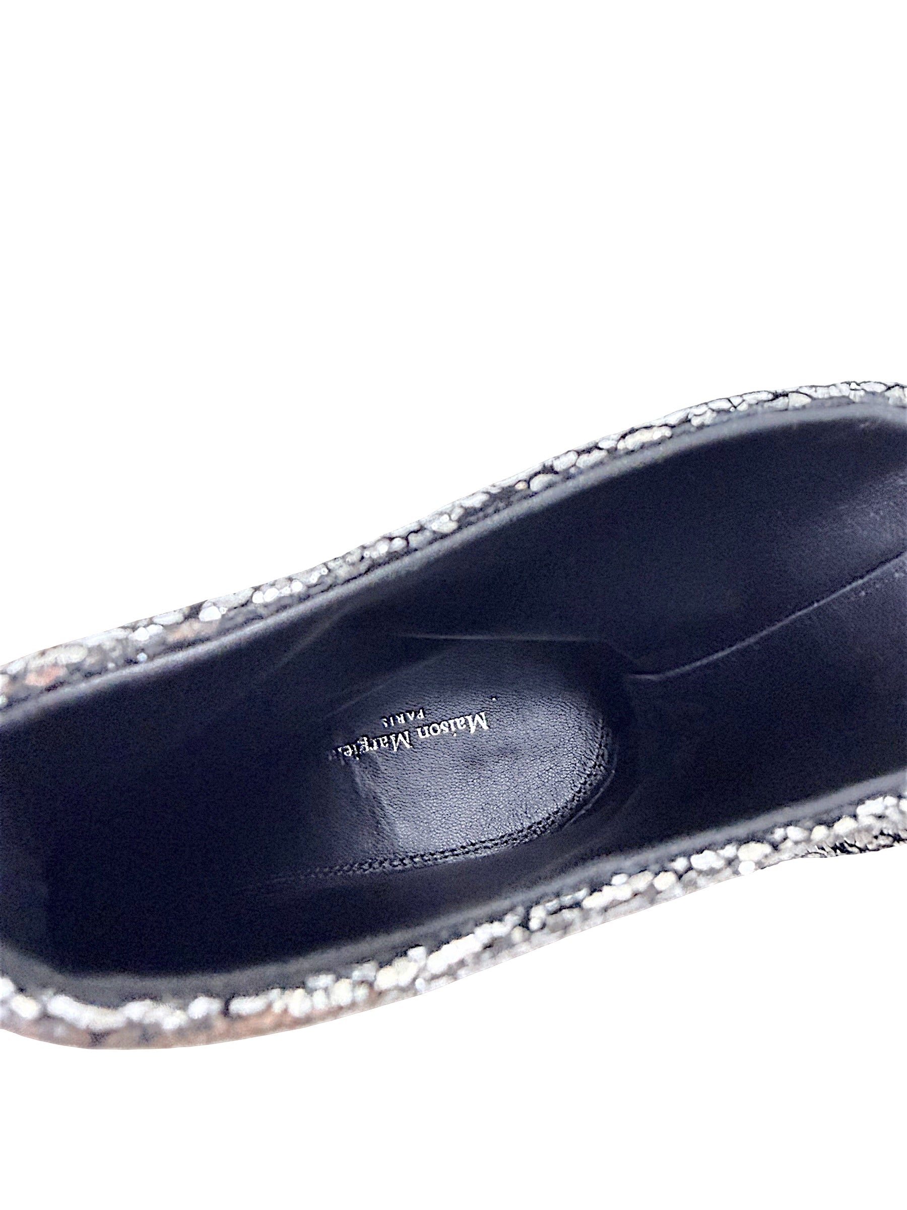 Close-up of black leather interior and Maison Margiela Paris logo inside silver metallic Tabi ankle boot