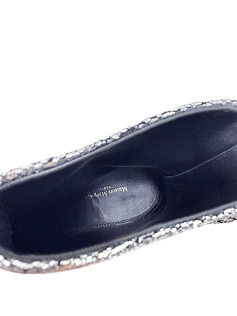 Close-up of black leather interior and Maison Margiela Paris logo inside silver metallic Tabi ankle boot
