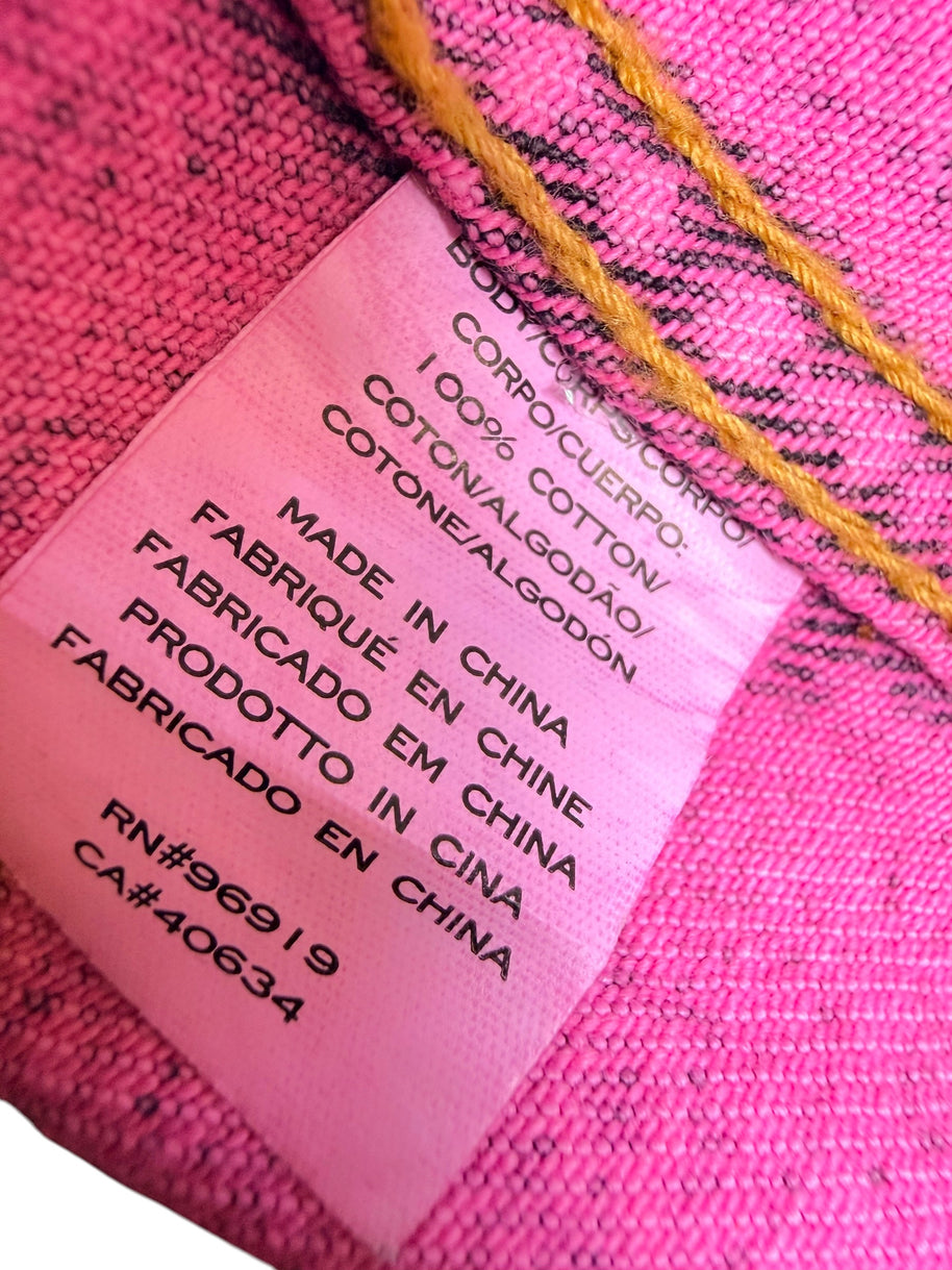 Close-up of Marc Jacobs Paradise pink denim jacket composition label confirming 100 percent cotton construction, made in China, and interior production codes.