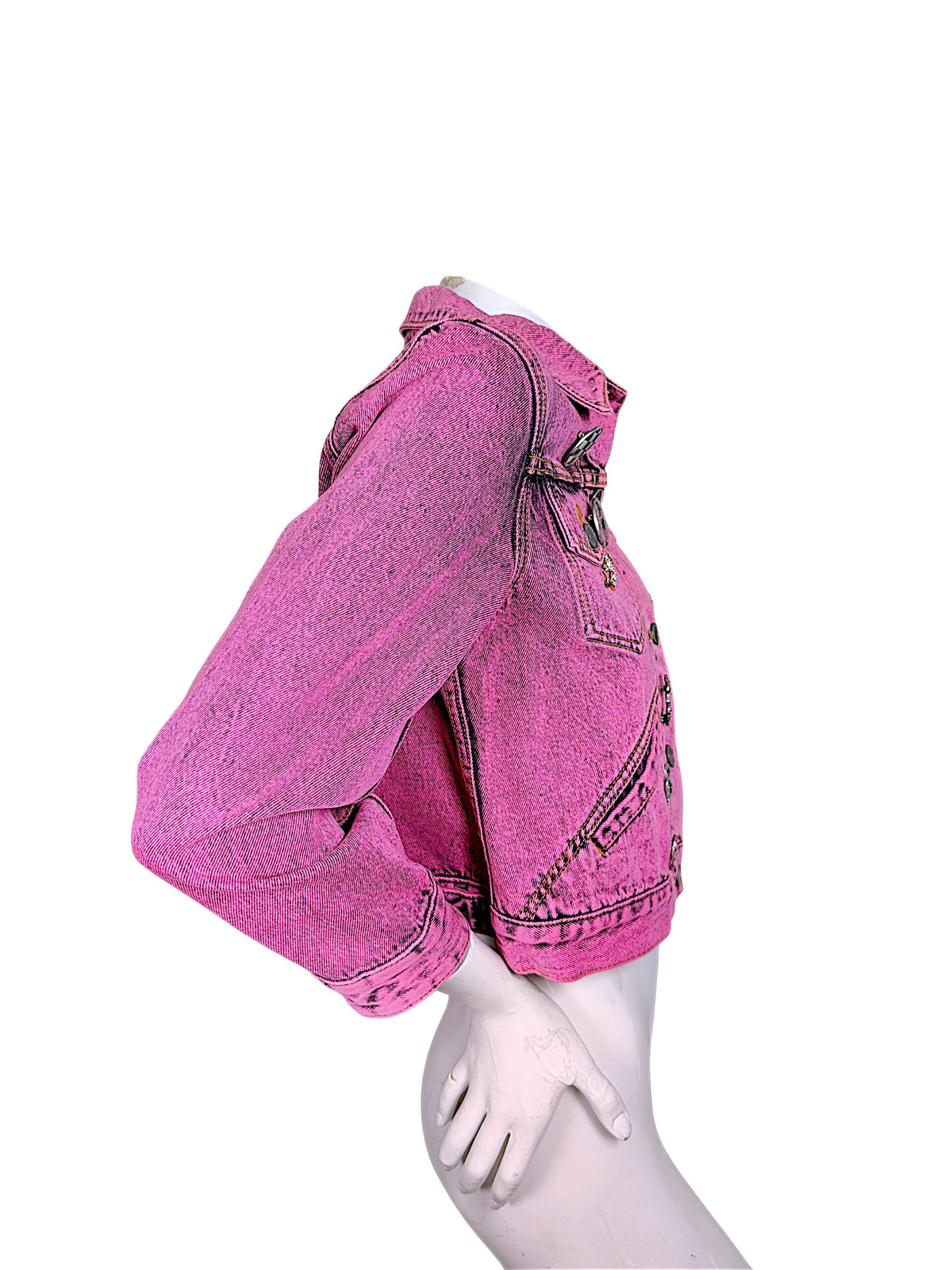 Side profile of Marc Jacobs Paradise pink acid wash denim trucker jacket showing cropped hem, structured shoulder and long button-cuff sleeve.