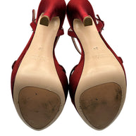 Underside of Miu Miu burgundy platform sandals showing leather outsoles with visible wear, heel tips and original designer markings.