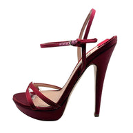 Side detail of Miu Miu burgundy satin platform heel showing the adjustable metal buckle, slim ankle straps and satin-covered stiletto.