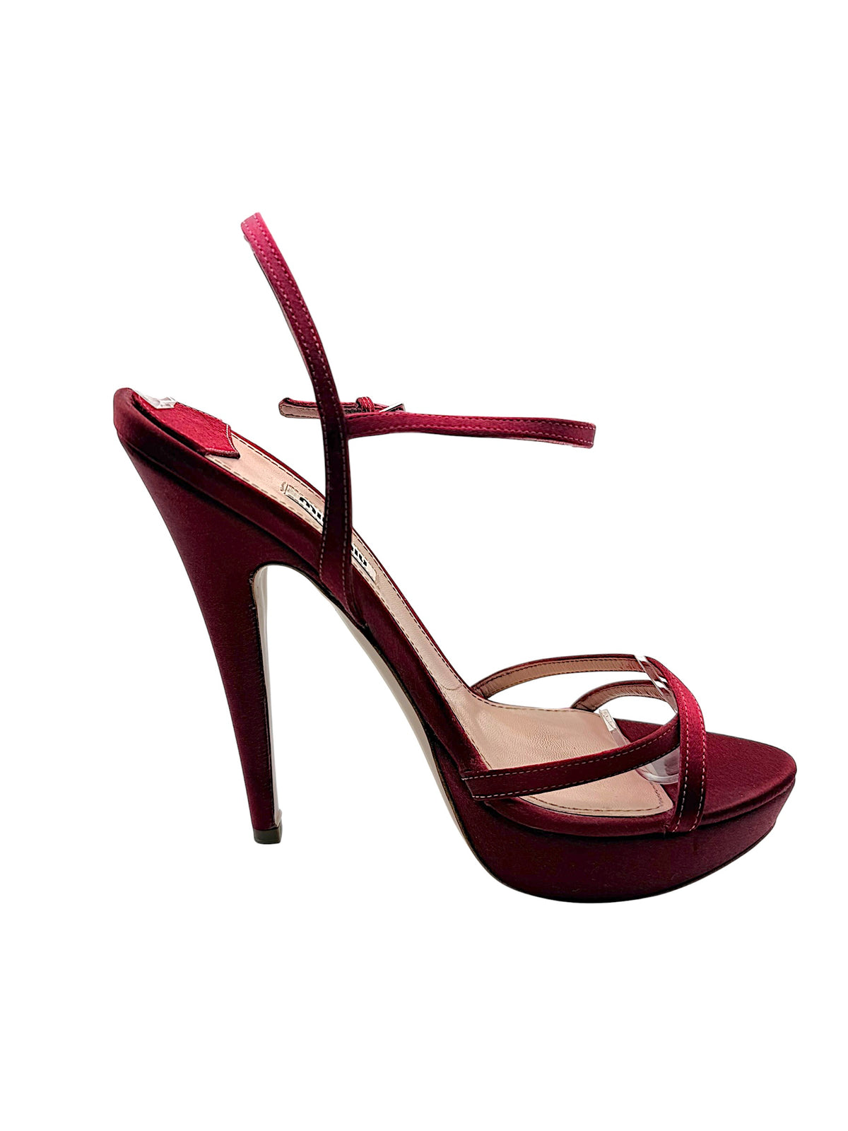 Outer side profile of a Miu Miu burgundy satin platform sandal featuring a slender stiletto heel, crisscross toe straps and raised sole.