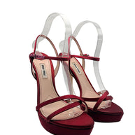 Pair of Miu Miu burgundy satin high heel sandals showing delicate crisscross front straps, covered platforms and slim stiletto heels.