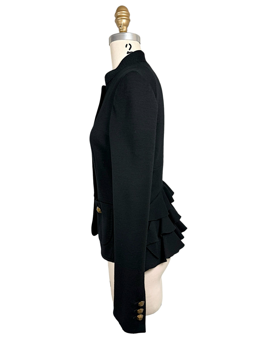 Opposite side view of Moschino black structured jacket displaying its slim fitted waist, stand collar, gold-tone cuff buttons and tiered back ruffles.