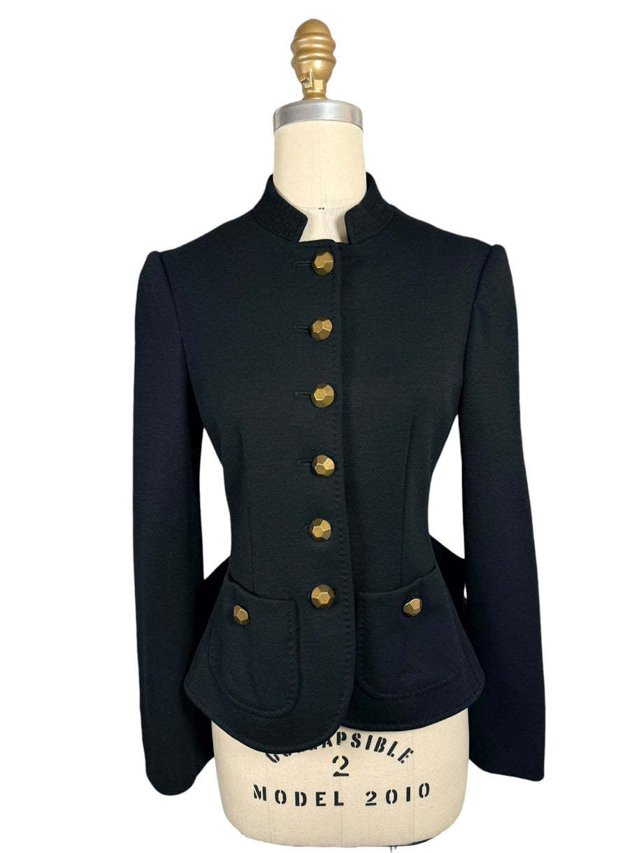 Front view of Moschino black structured jacket with six faceted gold-tone buttons, a fitted waist, stand collar and two rounded patch pockets.