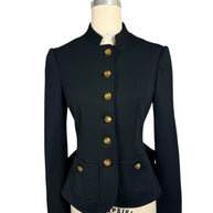 Front view of Moschino black structured jacket with six faceted gold-tone buttons, a fitted waist, stand collar and two rounded patch pockets.