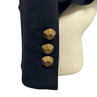 Close-up of Moschino black jacket sleeve cuff featuring three geometric faceted gold-tone buttons and neatly finished black fabric.