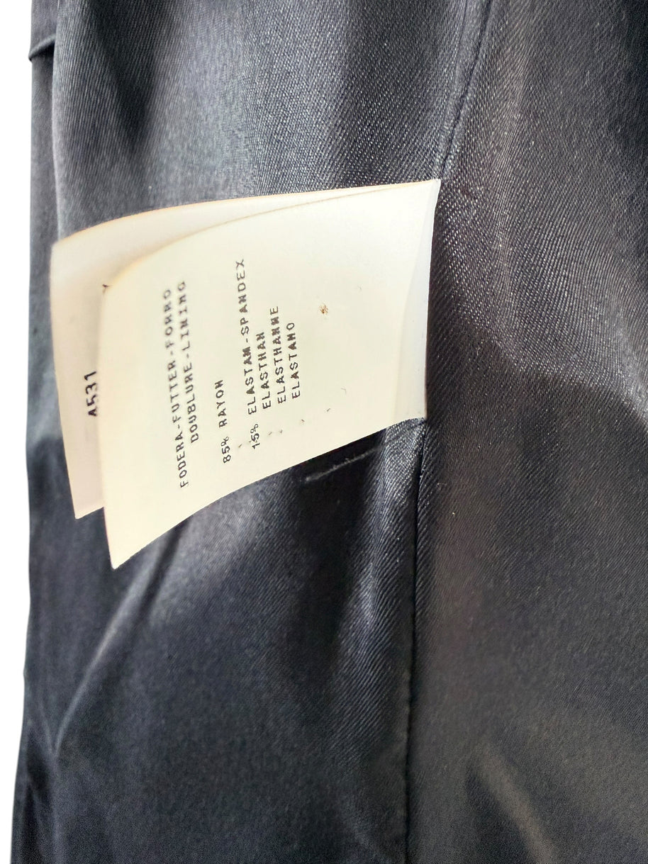 Close-up of Moschino black jacket composition label showing 85% rayon and 15% elastane-spandex, with the smooth black interior lining visible.