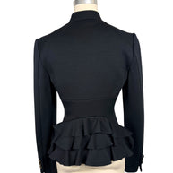 Full back view of Moschino black designer jacket featuring a sharply fitted waist and dramatic cascading tiers of fabric ruffles across the peplum hem.