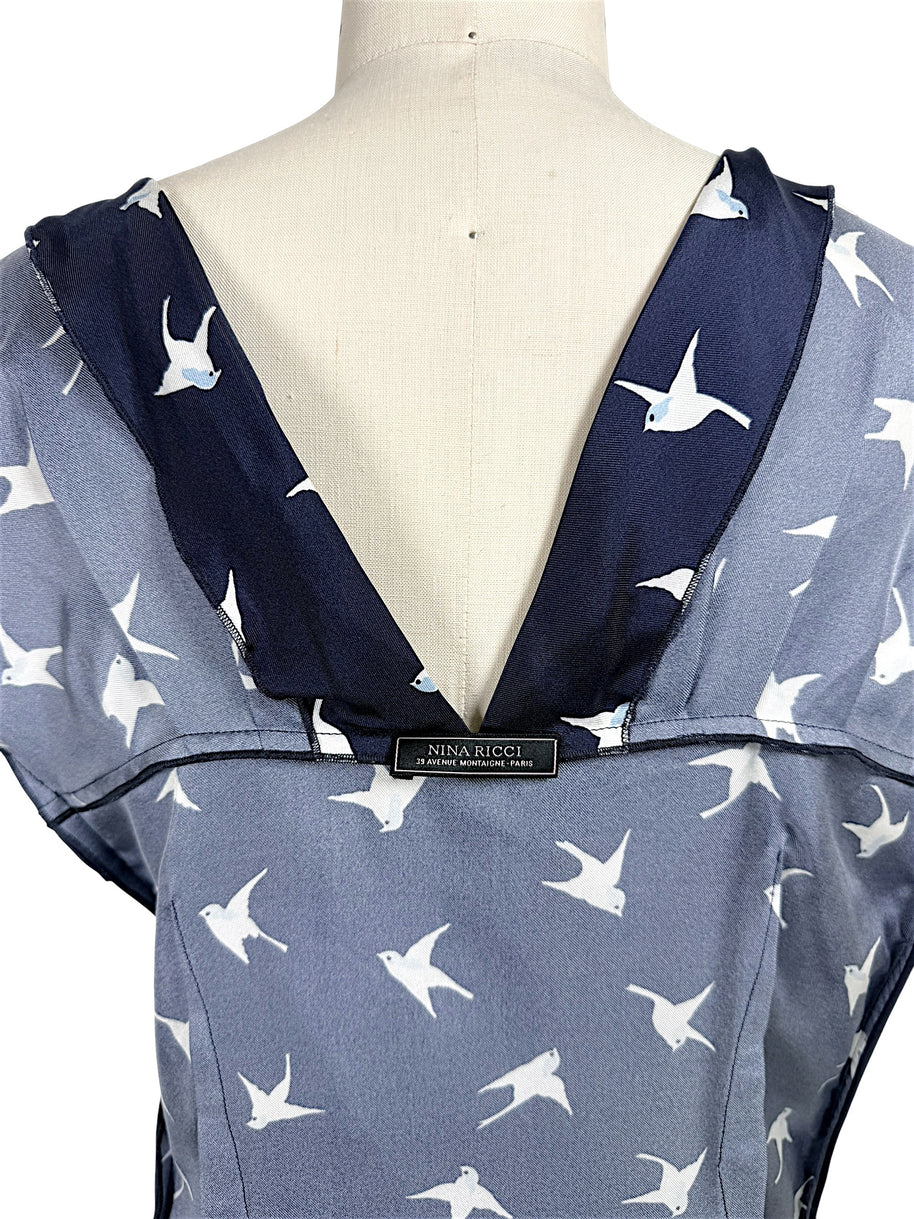 Interior Nina Ricci designer label shown on open back navy silk swallow print dress.