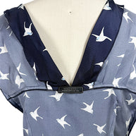 Interior Nina Ricci designer label shown on open back navy silk swallow print dress.