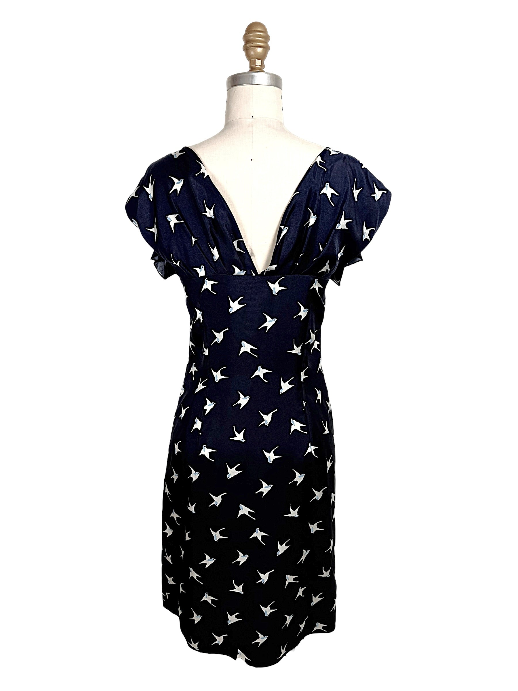 Back view of Nina Ricci navy silk dress with deep V open back and ivory bird print throughout.