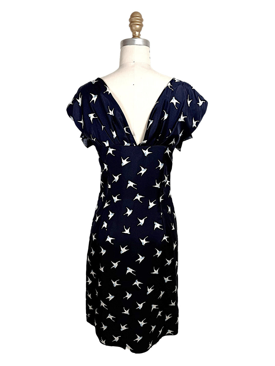 Back view of Nina Ricci navy silk dress with deep V open back and ivory bird print throughout.