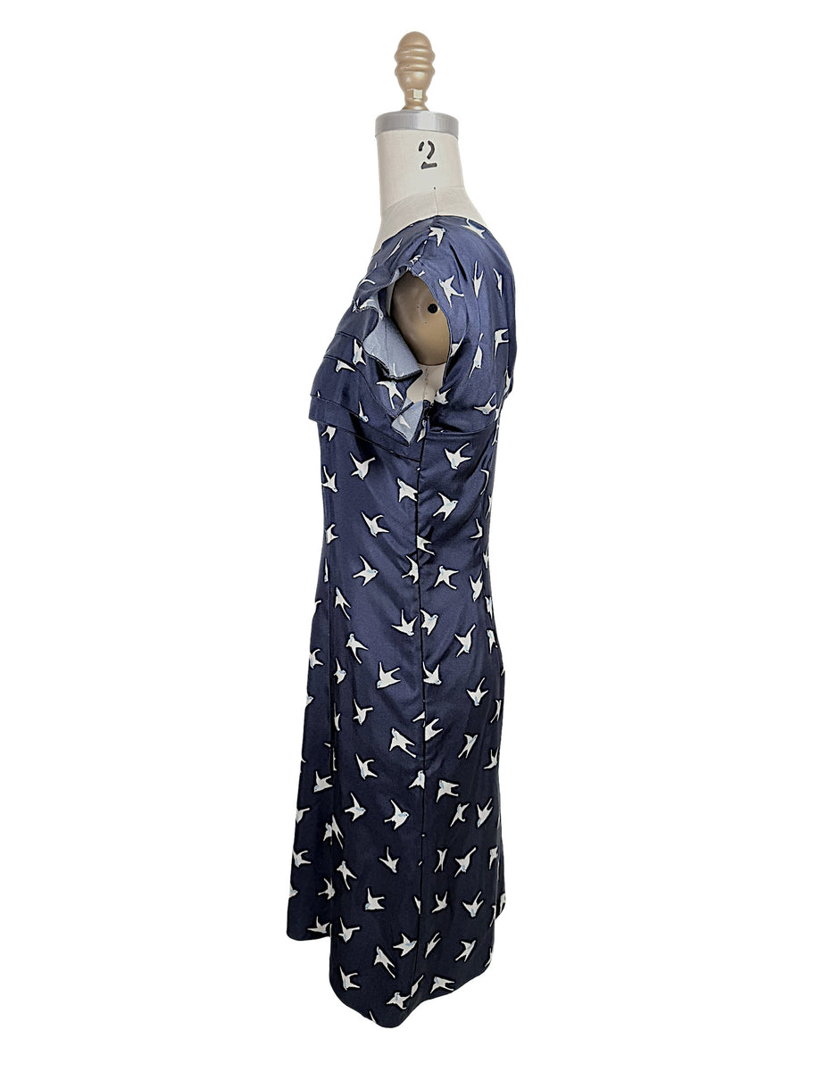 Side profile of Nina Ricci navy silk swallow print dress featuring layered ruffle neckline and fitted silhouette.