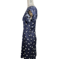 Side profile of Nina Ricci navy silk swallow print dress featuring layered ruffle neckline and fitted silhouette.