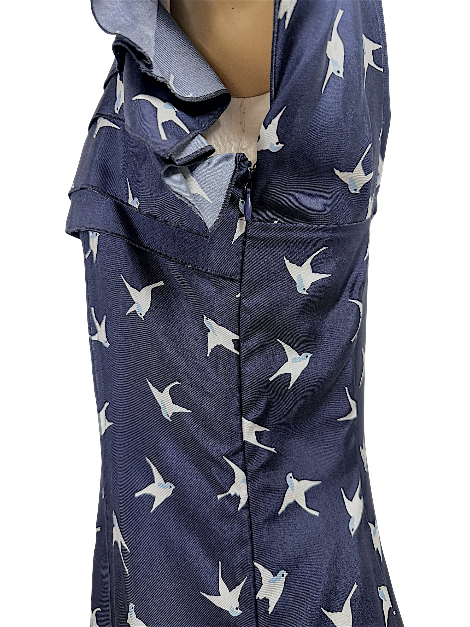 Close-up detail of concealed side zipper and silk swallow bird print fabric on Nina Ricci designer dress.