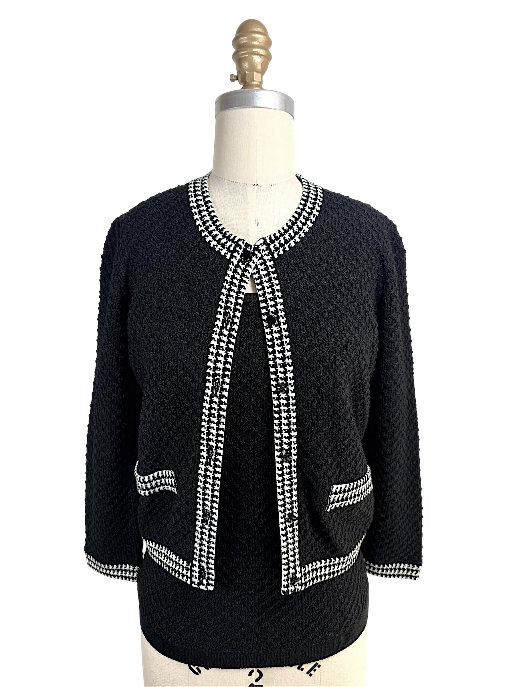 Front view of Oscar de la Renta black textured wool cardigan with black and white houndstooth trim and matching shell