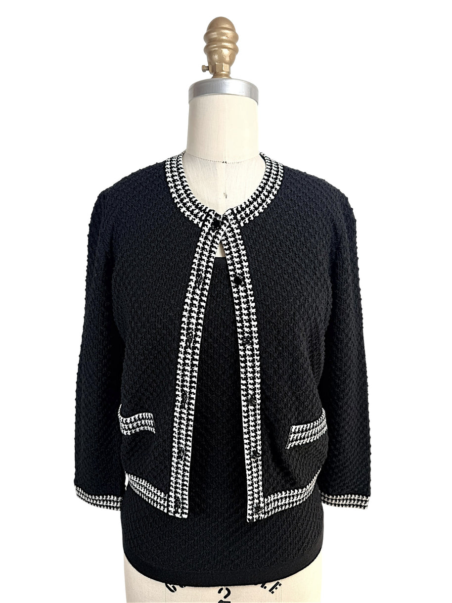 Front view of Oscar de la Renta black textured wool cardigan with black and white houndstooth trim and matching shell