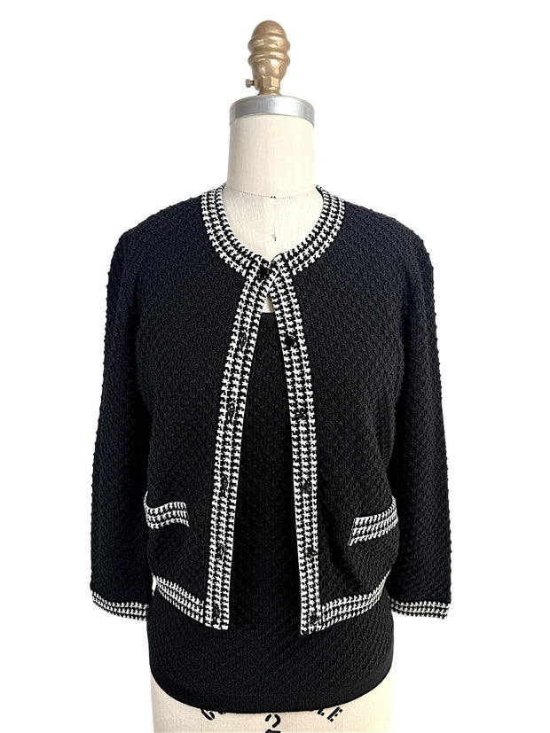 Front view of Oscar de la Renta black textured wool cardigan with black and white houndstooth trim and matching shell