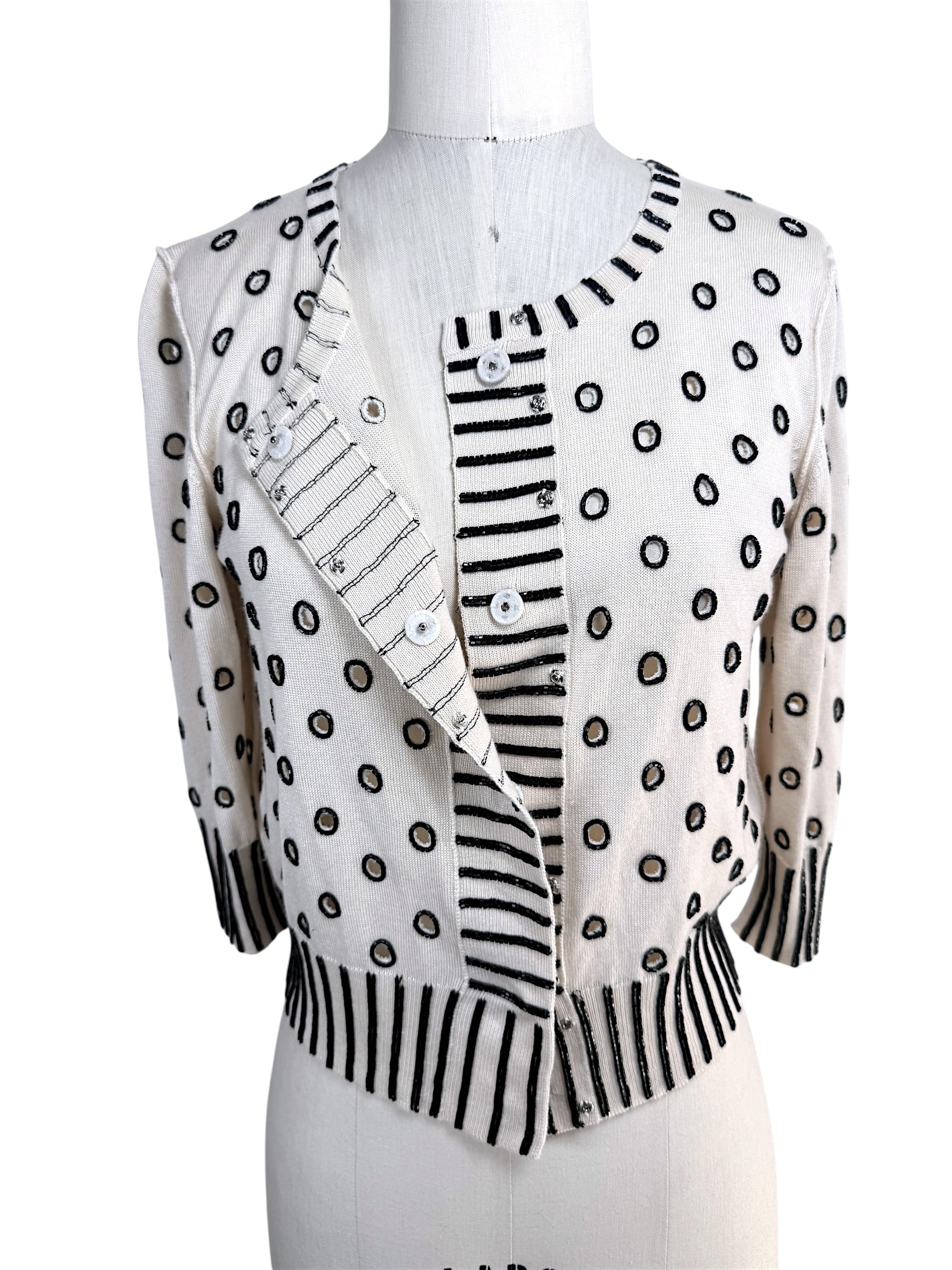 Oscar de la Renta ivory beaded cardigan shown partially open displaying concealed button front closure