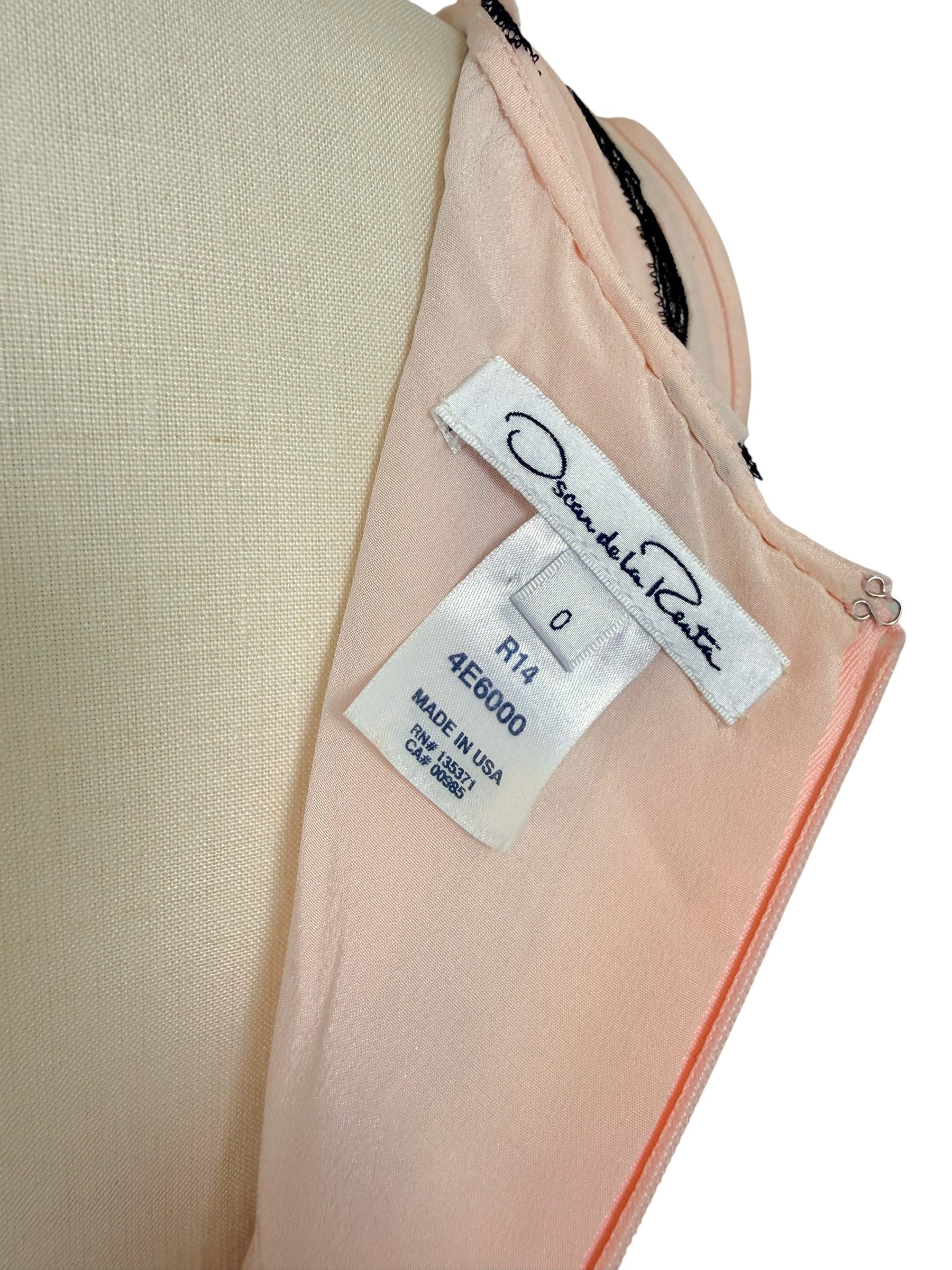 Close-up photograph of the Oscar de la Renta designer label showing size 0 and Made in USA manufacturing tag.