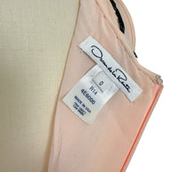Close-up photograph of the Oscar de la Renta designer label showing size 0 and Made in USA manufacturing tag.