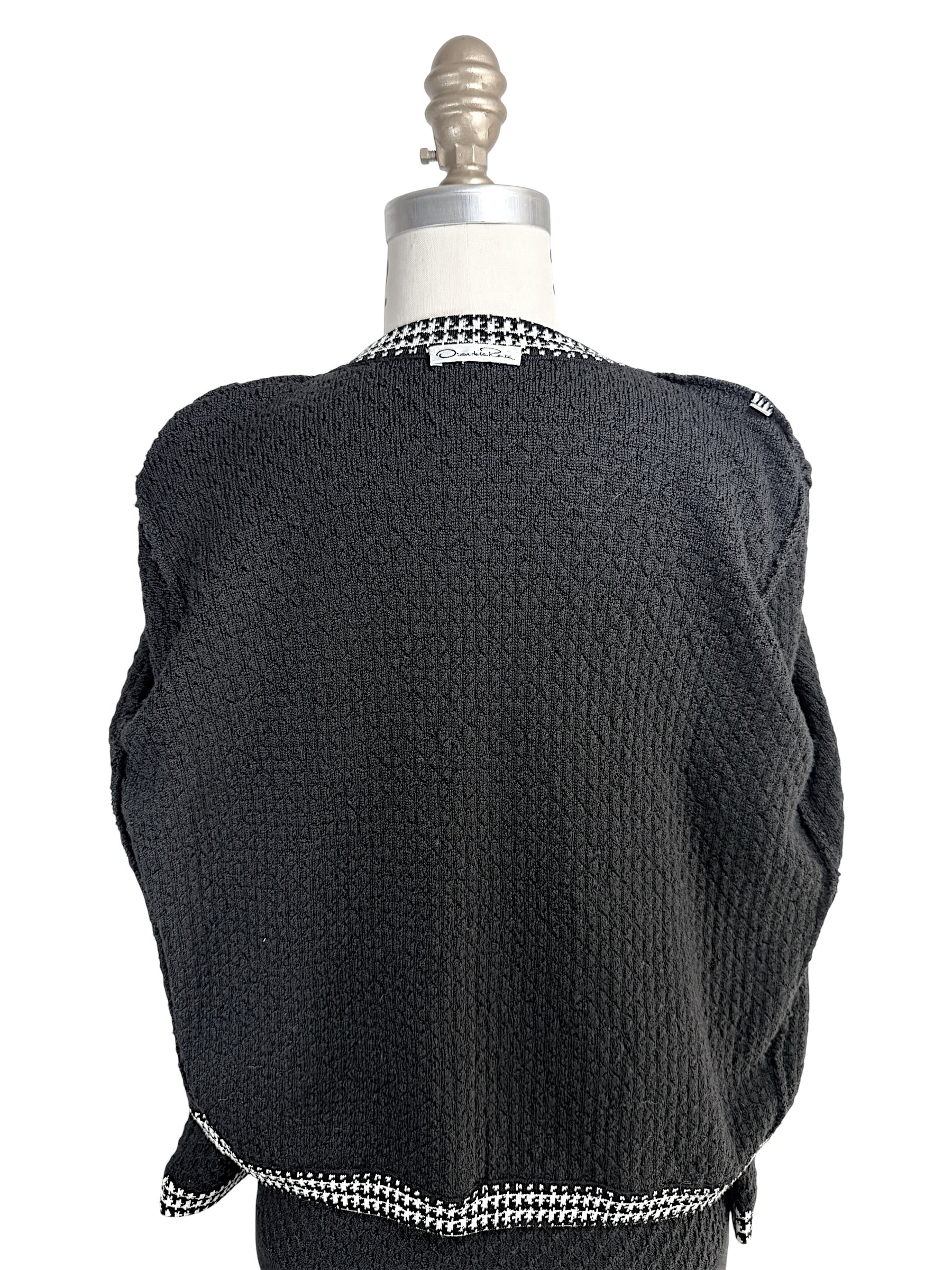 Full back view of Oscar de la Renta textured black wool cardigan on mannequin