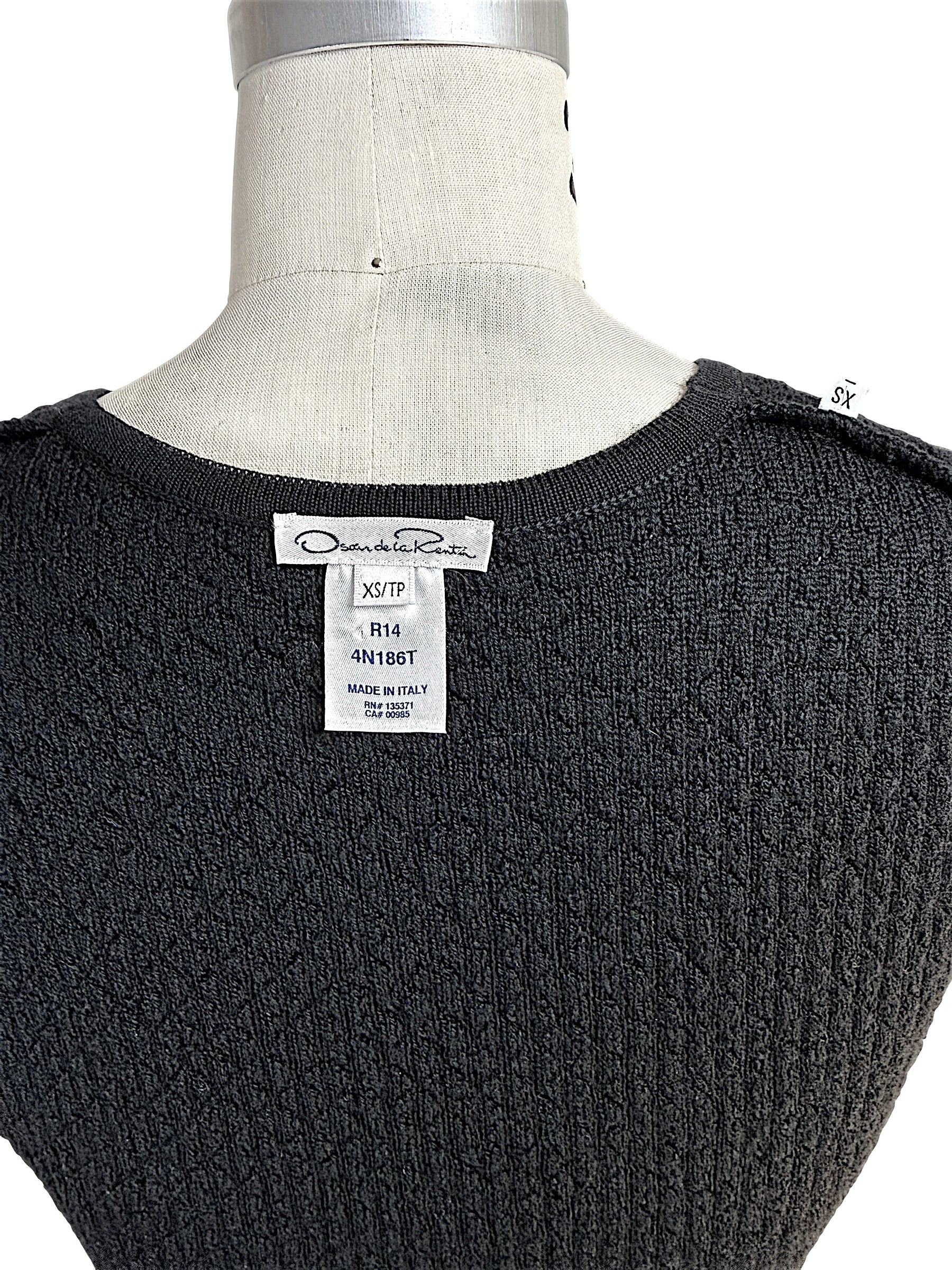 Back detail of Oscar de la Renta black textured knit shell showing designer label and textured knit fabric