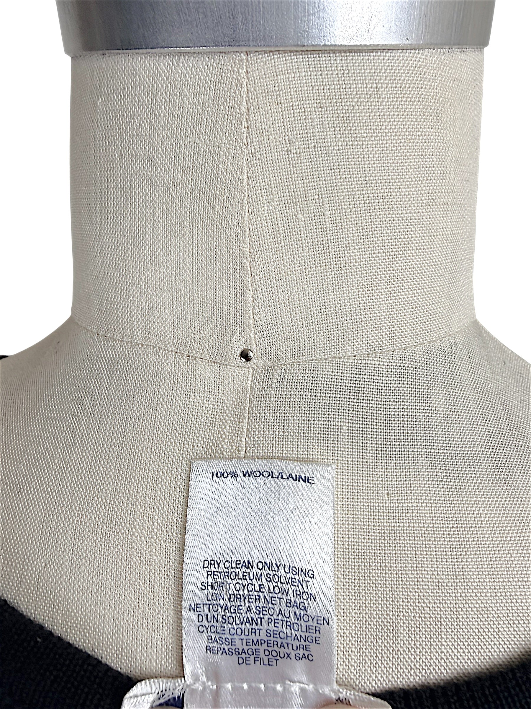 Oscar de la Renta knit shell interior care tag showing 100 percent wool composition and cleaning instructions