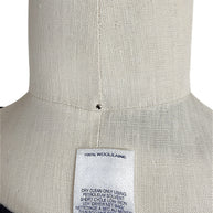 Oscar de la Renta knit shell interior care tag showing 100 percent wool composition and cleaning instructions