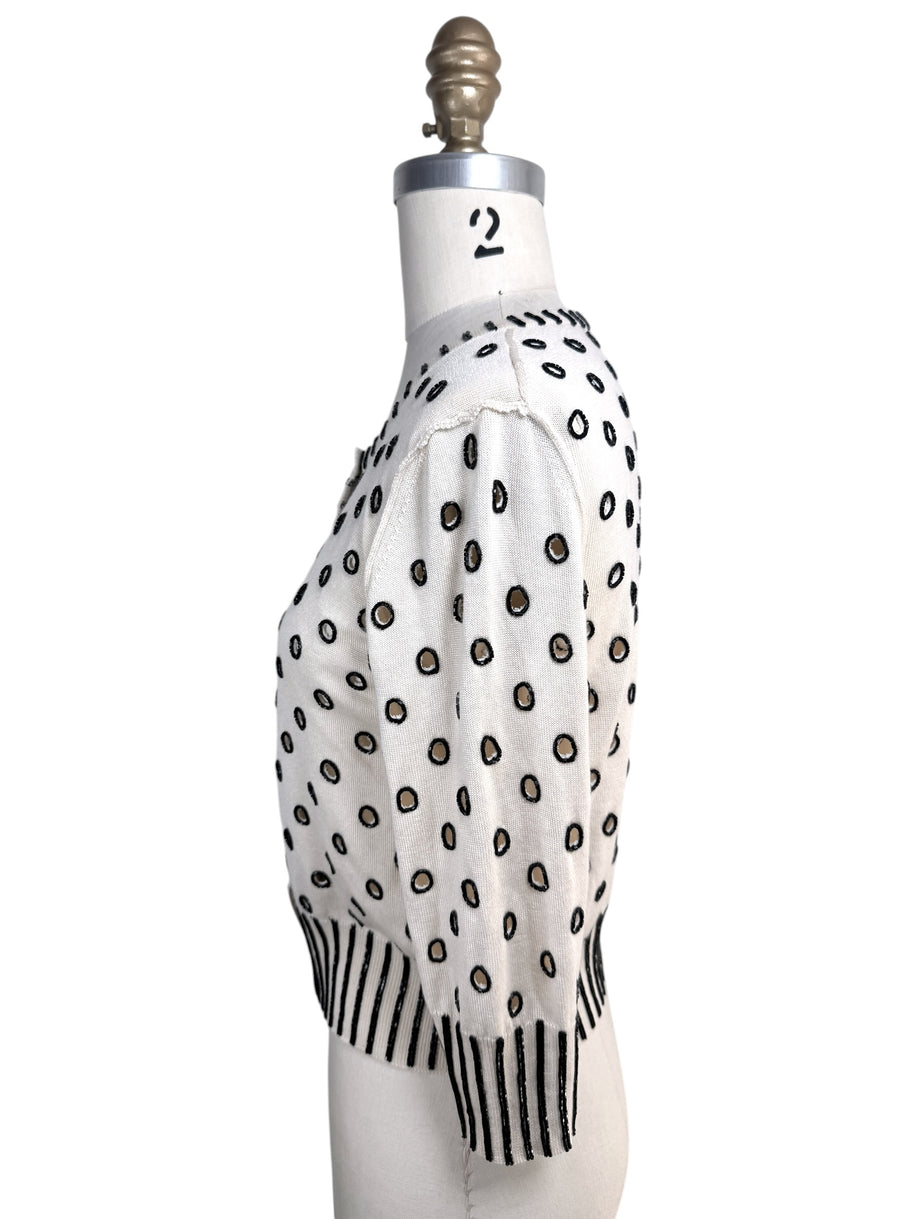 Left side profile of Oscar de la Renta ivory cropped cardigan with black beaded polka dot embroidery