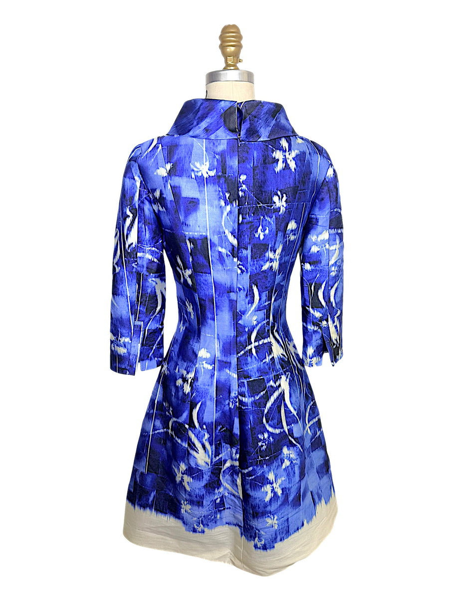 Rear view of the Oscar de la Renta Pre-Fall 2014 dress featuring a concealed zipper closure, sculptural collar, fitted seams, and painterly blue print.
