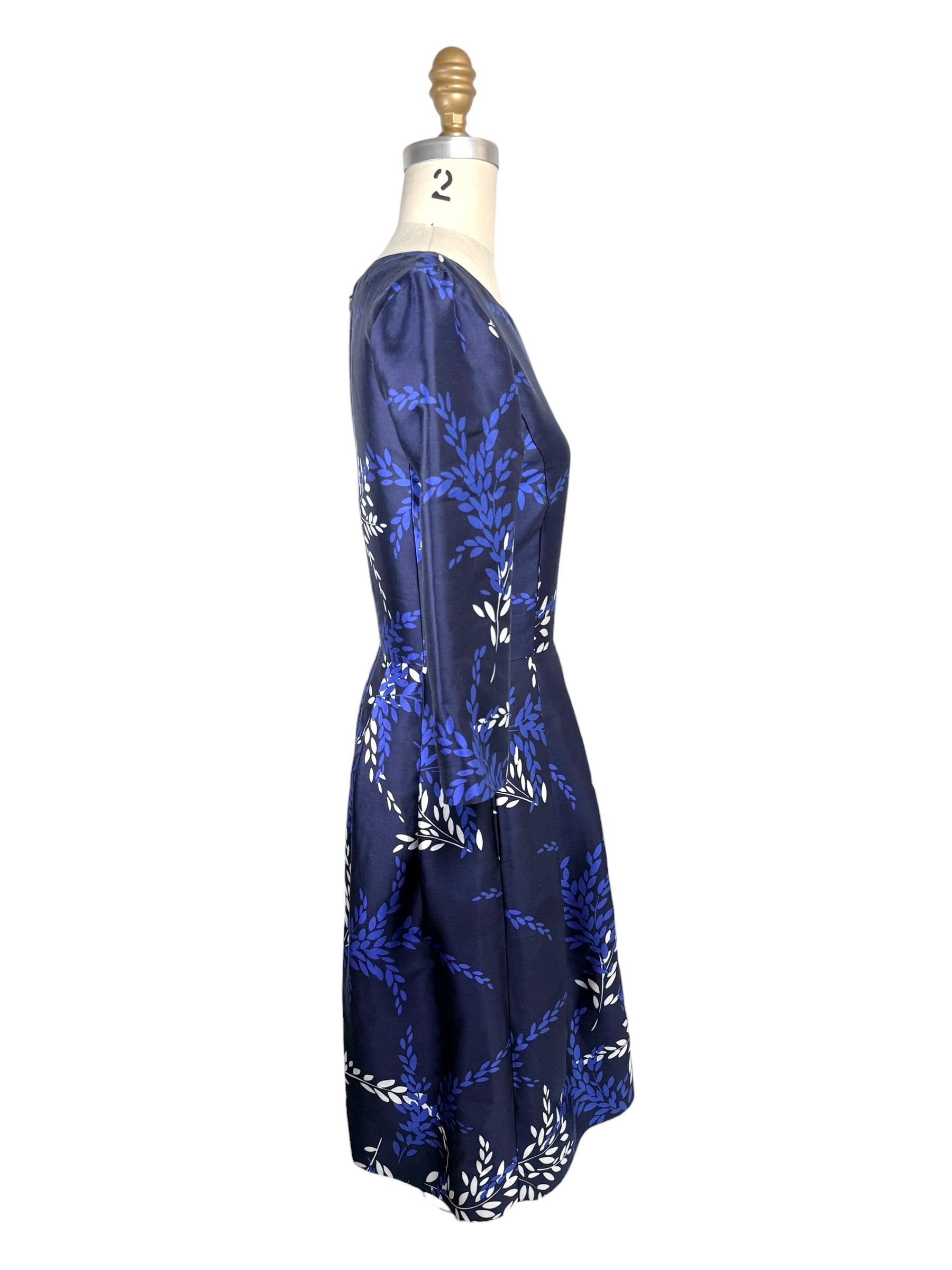 Side profile of Oscar de la Renta Pre-Fall 2017 navy fit-and-flare dress with three-quarter sleeves and laurel motif print