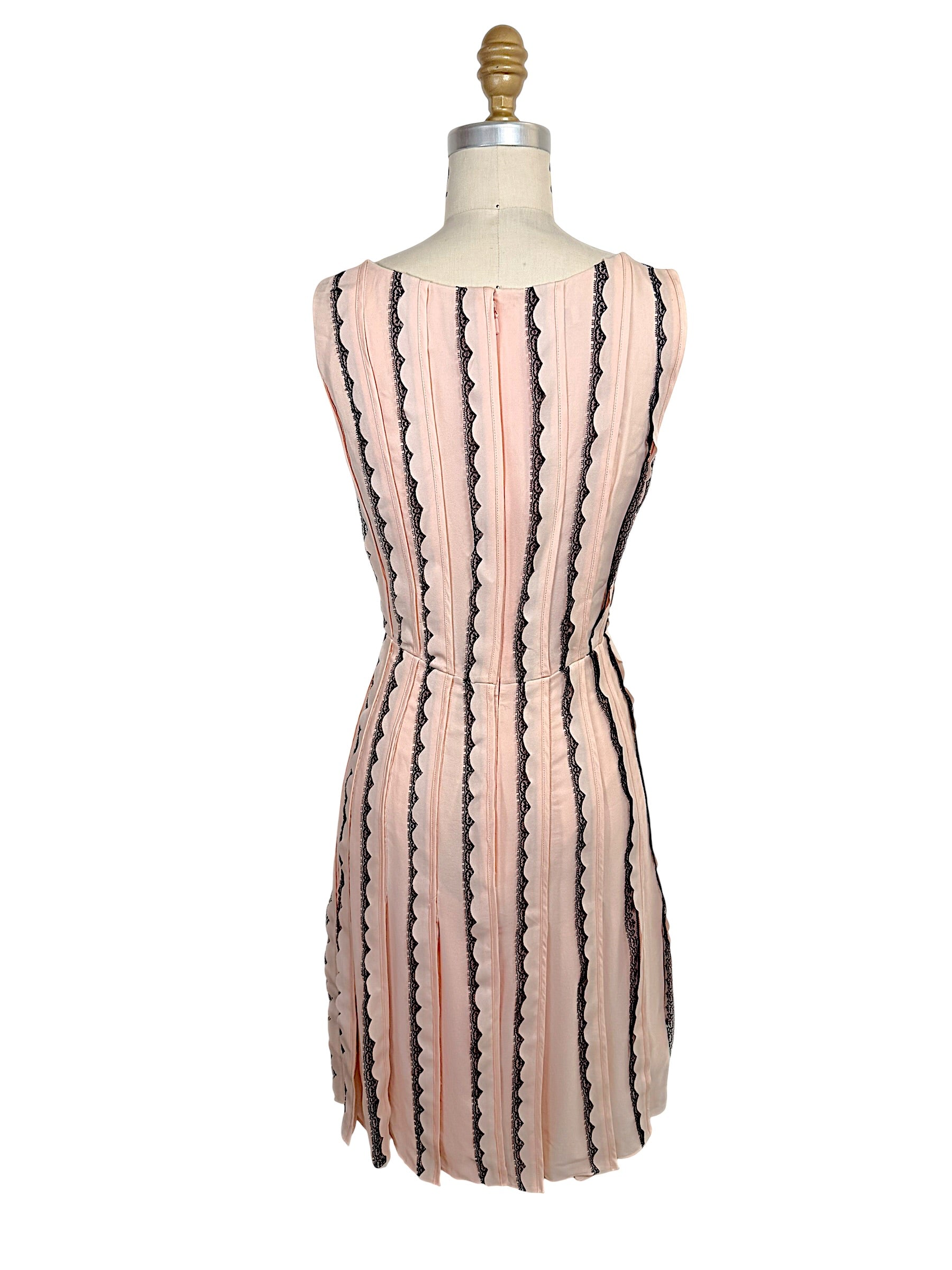 Rear view of the Oscar de la Renta Resort 2014 blush pink sleeveless dress featuring a concealed back zipper and vertical black lace stripe detailing.