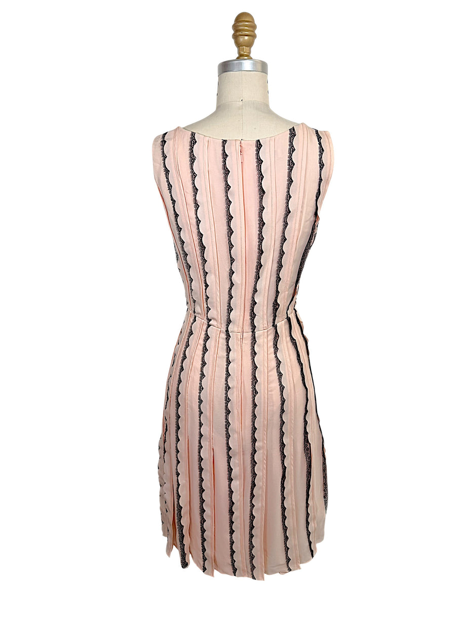 Rear view of the Oscar de la Renta Resort 2014 blush pink sleeveless dress featuring a concealed back zipper and vertical black lace stripe detailing.